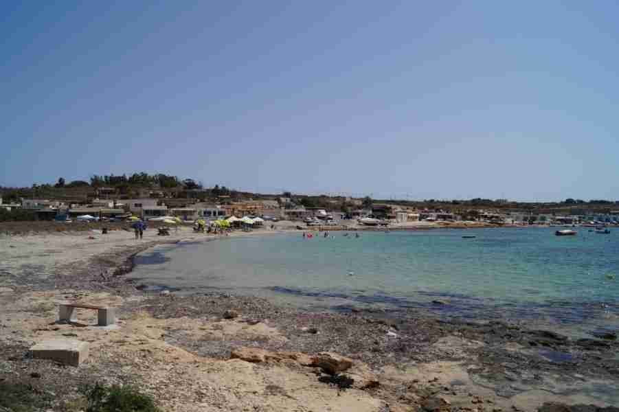 Sonnenliegen und entspannte Besucher am natürlichen Strand von Armier Bay