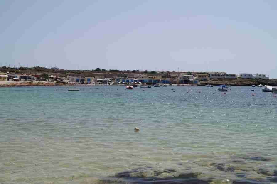 Kristallklares, türkisblaues Wasser am Sandstrand von Armier Bay auf Malta