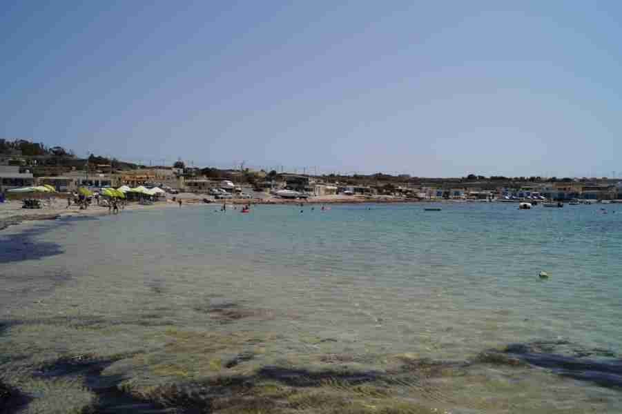 Sonnenliegen und entspannte Besucher am malerischen Strand von Armier Bay