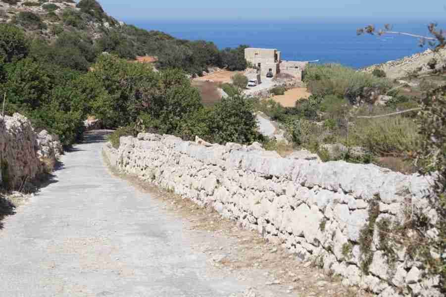 Wanderer genießt die Küstenlandschaft und entdeckt, dass Malta Sandstrände wie Imgiebah Bay bietet.