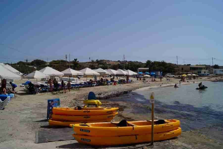 Wassersportler beim Jetski-Fahren in der Bucht von Little Armier Bay, vor der Kulisse des türkisen Mittelmeers.