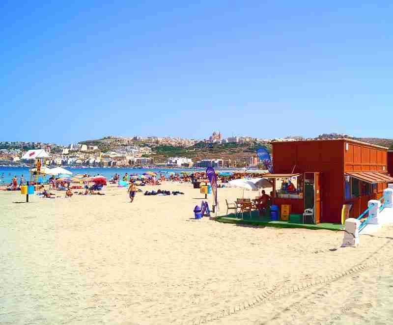 Freizeitangebote und Liegen am Sandstrand Mellieha Bay auf Malta.