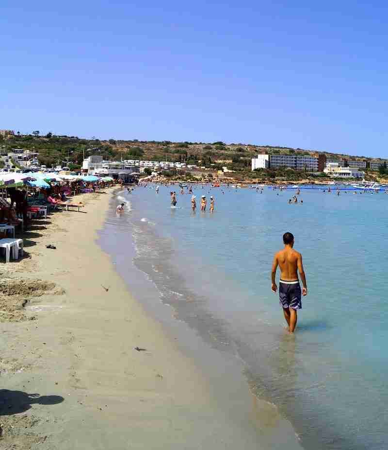 Mellieha Bay, einer der längsten Sandstrände auf Malta, mit türkisblauem Wasser.