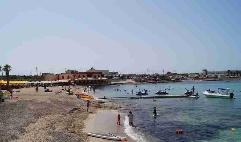Aktivitäten am Palm Beach: Wassersportler beim Paddeln und Jet-Ski-Fahren im türkisfarbenen Meer.