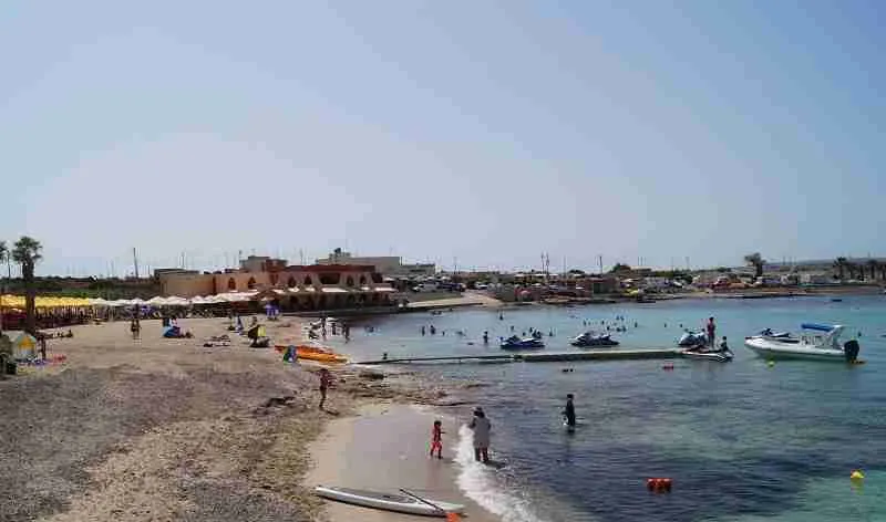 Aktivitäten am Palm Beach: Wassersportler beim Paddeln und Jet-Ski-Fahren im türkisfarbenen Meer.