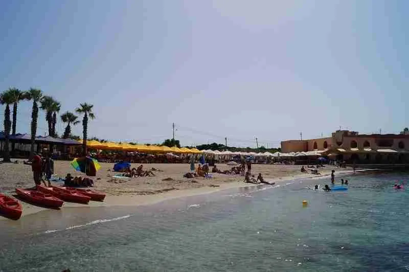Palm Beach auf Malta: Sandstrand mit türkisblauem Wasser und sanft abfallendem Ufer, ideal für Familien und Sonnenanbeter.