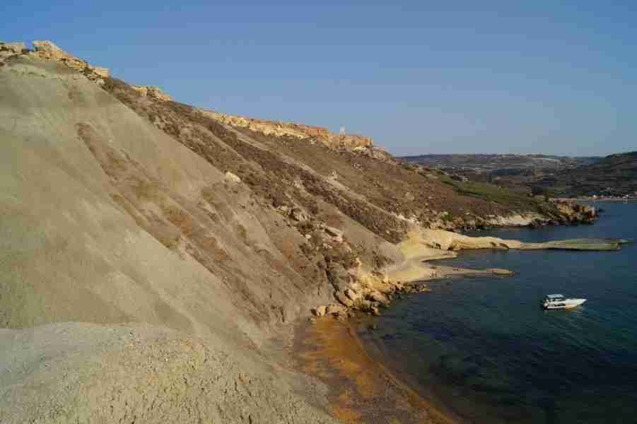 Ein malerischer Blick auf Secret Ghajn Tuffieha Bay, einem der schönsten Strände auf Malta, umgeben von unberührter Natur und türkisfarbenem Wasser.