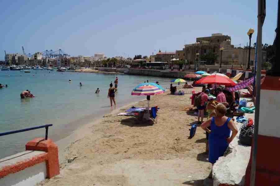 Einheimische genießen die Sonne und das türkisfarbene Wasser in einer der kleinen Buchten Maltas.