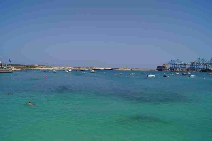 Blick auf das glitzernde Wasser und den feinen Sand von Pretty Bay – ein klarer Beweis, dass es auf Malta Sandstrände gibt.